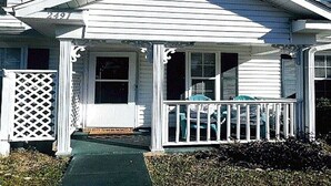A white house with a porch, a number 2491, and a lattice fence.