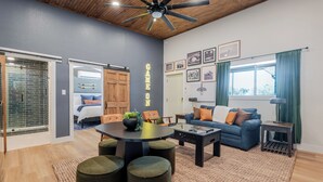 A modern living room with a round table, sofas, and a ceiling fan. - Lakeside Sandlot-New-Wiffle ball field+Hot Tub-Close to Rocker B-Family Fun! (Graford)