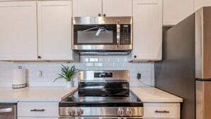 A modern kitchen with stainless steel appliances, including a microwave, oven, and refrigerator. - Lakeside Sandlot-New-Wiffle ball field+Hot Tub-Close to Rocker B-Family Fun! (Graford)