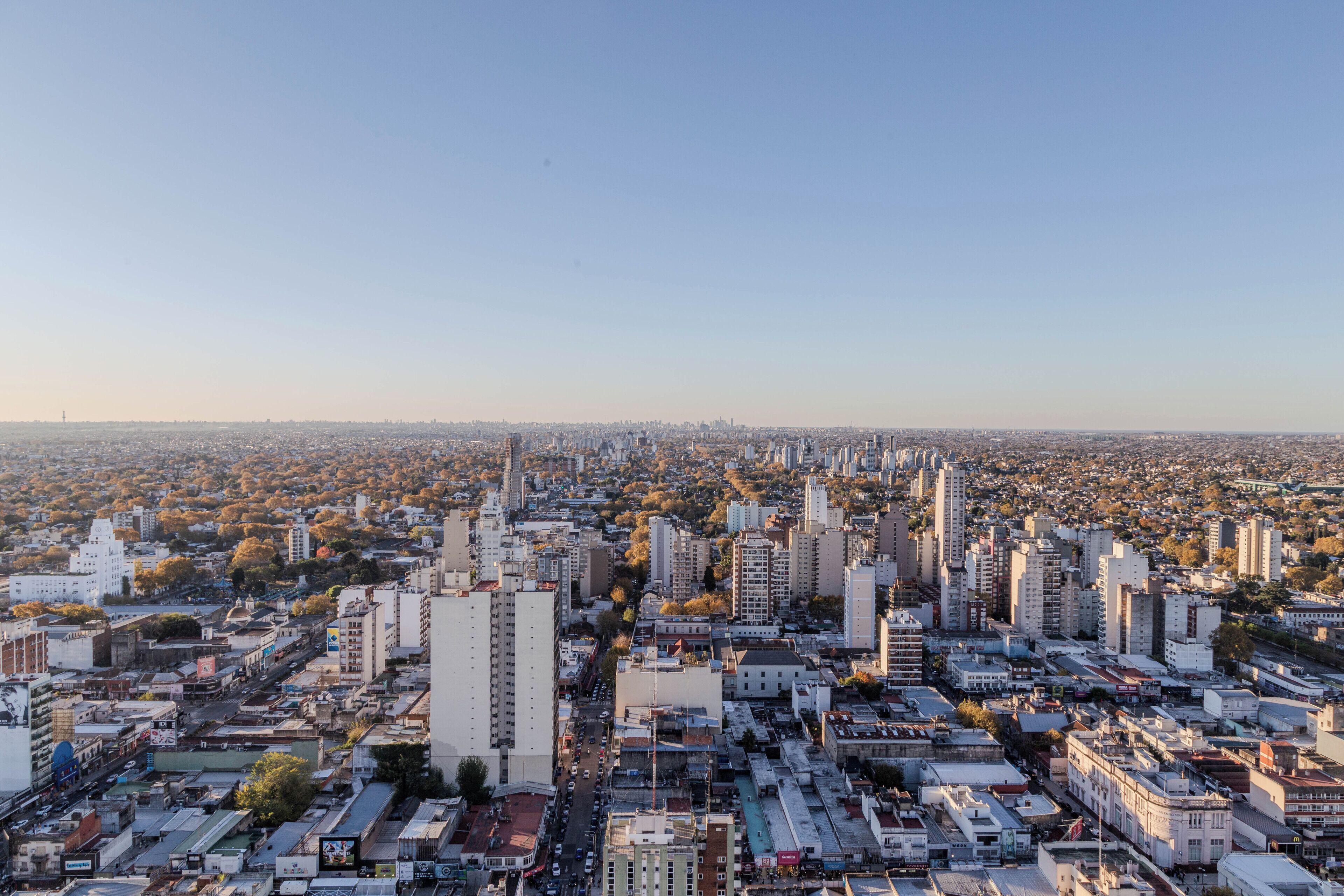 A cityscape with dense urban buildings, streets, and a clear sky.
