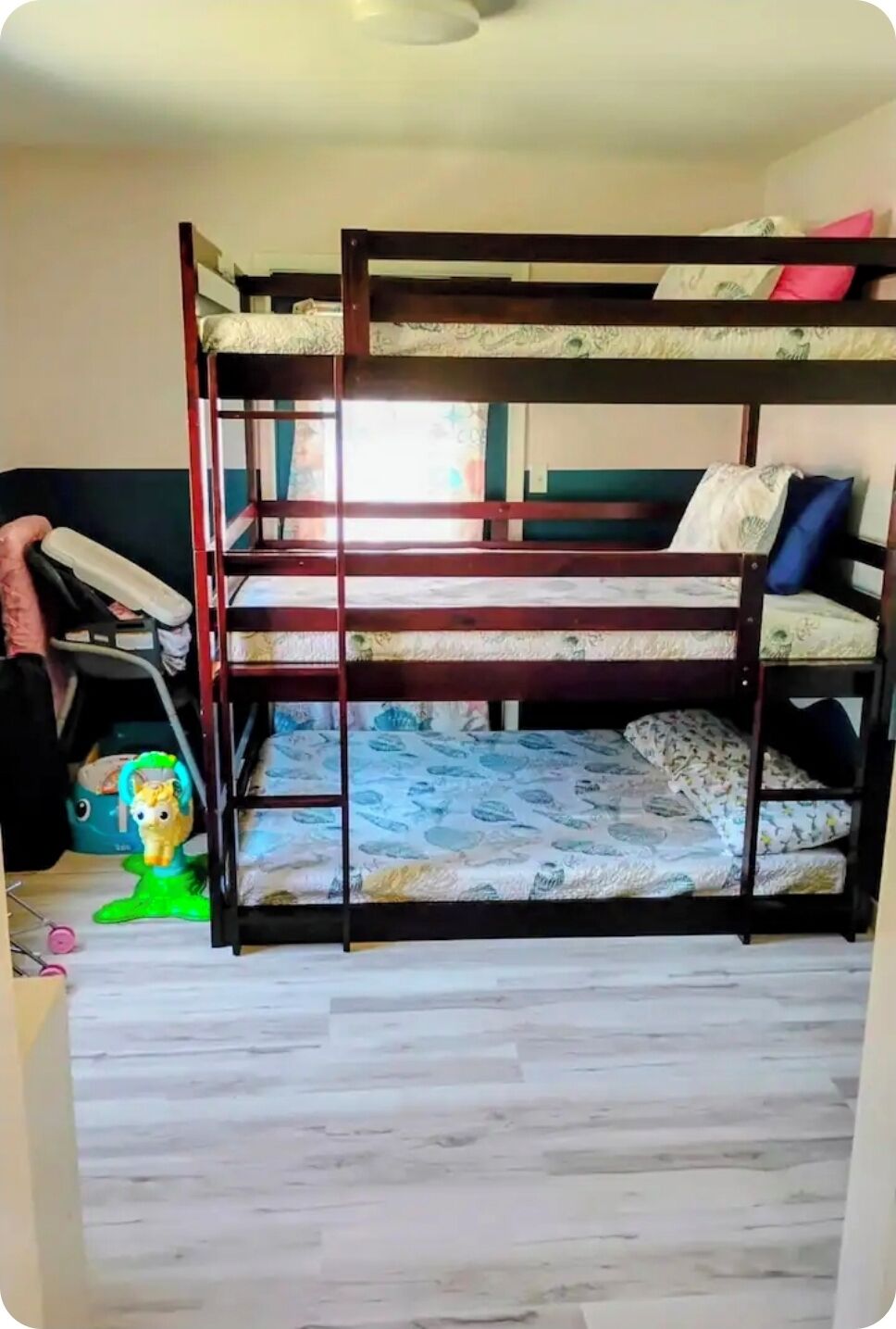 A bunk bed with a wooden frame, a toy horse, and a green toy on the floor.