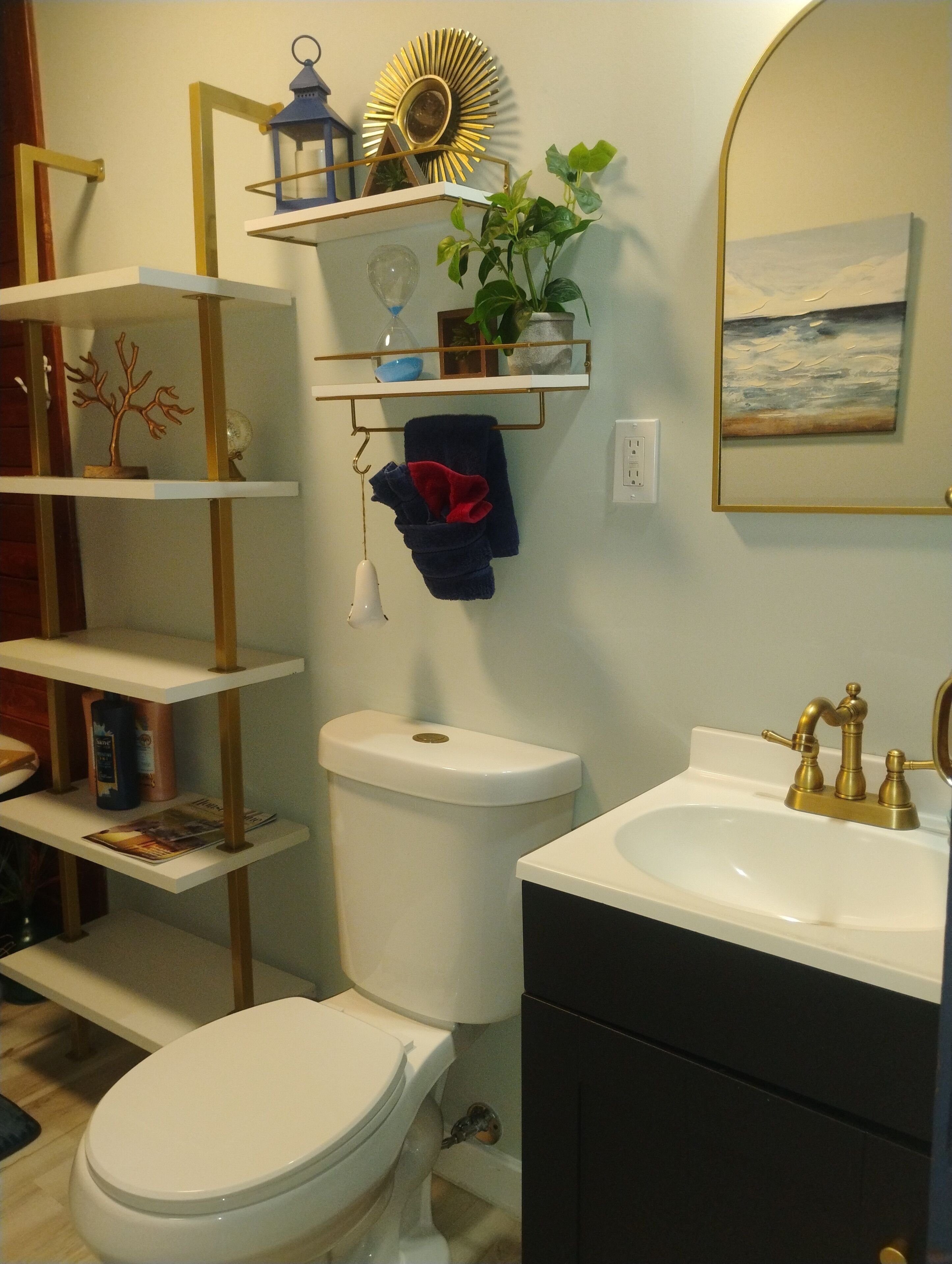 Ein Badezimmer mit Toilette, Waschbecken und Regalen mit Pflegeprodukten.