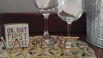 Twee wijnglazen op een decoratief dienblad met de letters ‘WINE’ in goud.