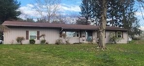 A single-story house with a front porch, a garage, and a large tree in front. - Hamilton's Hideaway, 3 Bdrm, Amazing 70s Retro Home, 15 mins to NFL Hall Of Fame (Uniontown)