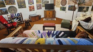 A cozy room with a bed, a chair, a wooden cabinet, and a television.