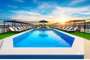 A swimming pool with lounge chairs and umbrellas, surrounded by a railing and a view of the sunset. - Nile Cruise Royal Adventure 3 every Friday from Aswan 3 nights and every Monday from Luxor 4 nights. (Aswan)