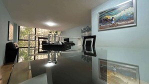 A modern room with a large window, a desk with a computer, and a wall-mounted TV. - Close to the best places in Polanco (Ciudad de México)