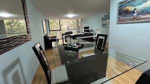 A modern dining area with a glass table and chairs, a sofa, and a painting on the wall. - Close to the best places in Polanco (Ciudad de México)