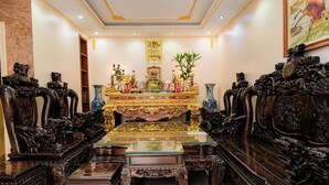 A traditional room with ornate furniture, a central table with a golden cloth, and a decorative altar. - Sky 2 Hotel (Kinh Bac)
