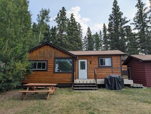A rustic cabin with a wooden exterior, a front door, and a small porch. - Boreal Owl: A cozy 1-bedroom lakefront cabin at Clearwater Lake (Clearwater Lake)