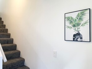 A staircase with carpeted steps leading to a landing.