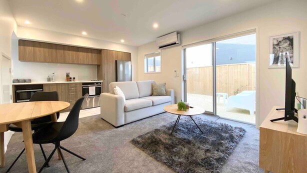 Un salon moderne avec un canapé, une table basse et un coin repas.