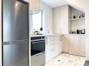 Una cucina moderna con elettrodomestici in acciaio inossidabile, mobili in legno e un pavimento in marmo.