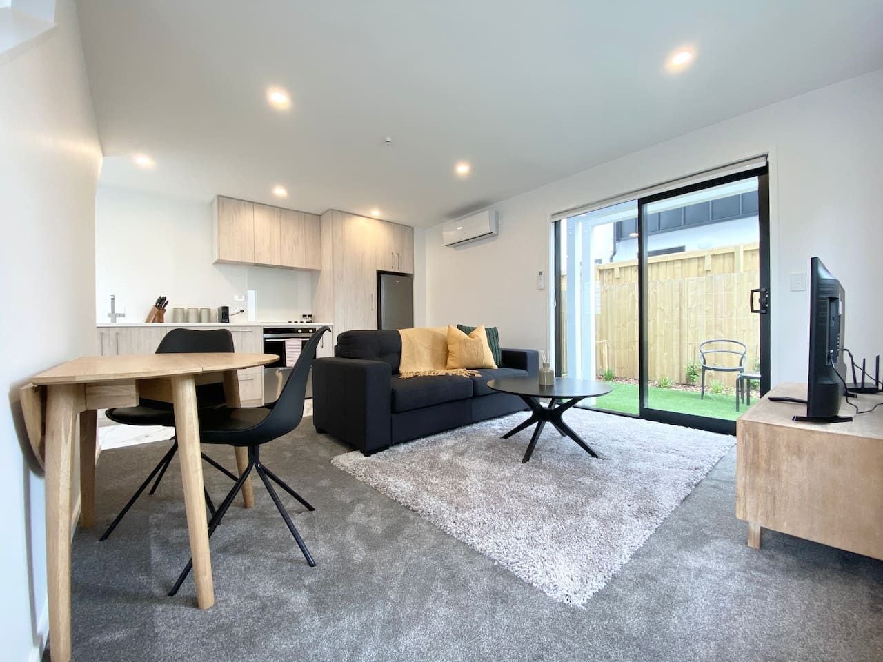 Ein modernes Wohnzimmer mit Sofa, Couchtisch und Essbereich.