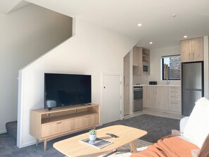 Ein modernes Apartment mit Wohnzimmer, Küche und Essbereich.