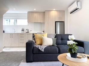 Eine moderne Küche mit hellen Holzschränken, einem eingebauten Ofen und einem Edelstahlkühlschrank.