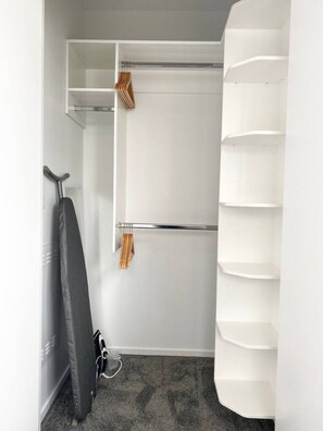 Armadio a muro con scaffali aperti, appendiabiti e porta scarpe.