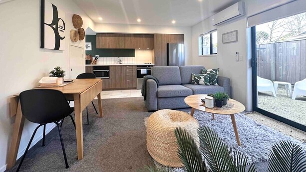 Um espaço de estar moderno com área de refeições, cozinha e local para sentar.