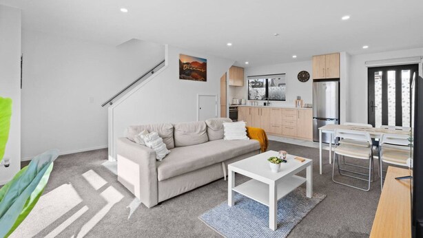 Un salon moderne avec un canapé, une table basse et un coin repas.