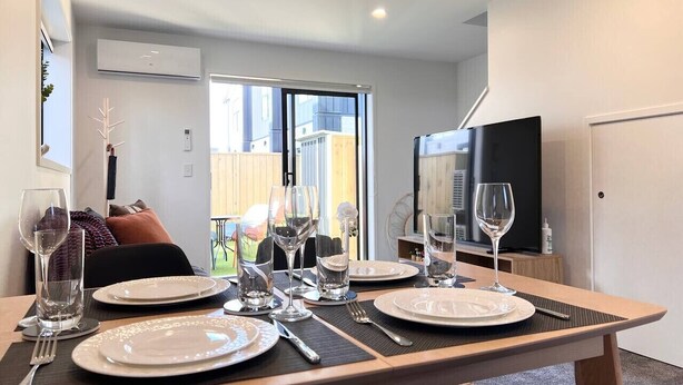 A dining area with a table set for four, including plates, glasses, and cutlery.