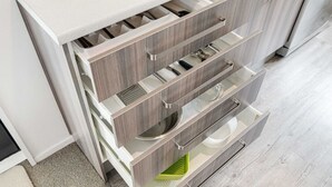 Eine Küche mit eingebautem Gerät, Holzschränken und einer Arbeitsplatte.