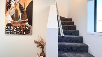 A staircase with a metal handrail and a window to the right.