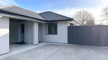 A residential house with a covered patio, a garage, and a fenced backyard.