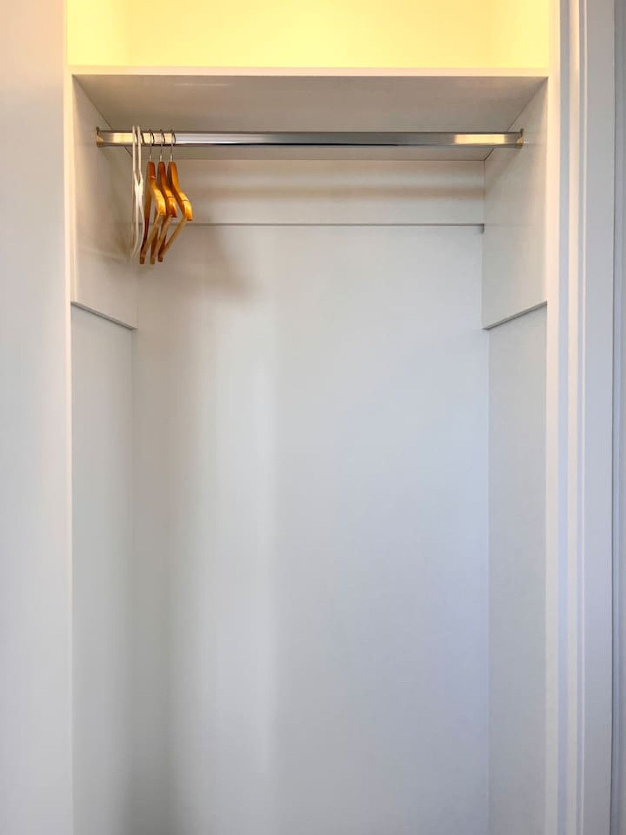 Een kast met een hangstang en een metalen stang voor kleding.
