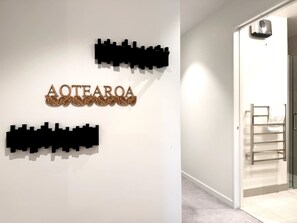 Un pasillo con un cartel en la pared que dice 'AOTEAROA' y un perchero.