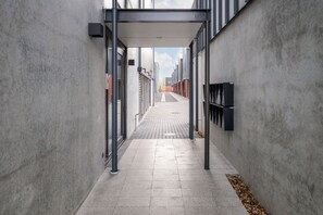 A narrow alleyway with a covered walkway, concrete walls, and a tiled floor. - Cashel penthouse with city balcony and parking in Christchurch (Christchurch)