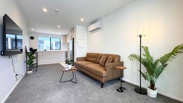 A modern living room with a sofa, a coffee table, and a floor lamp.