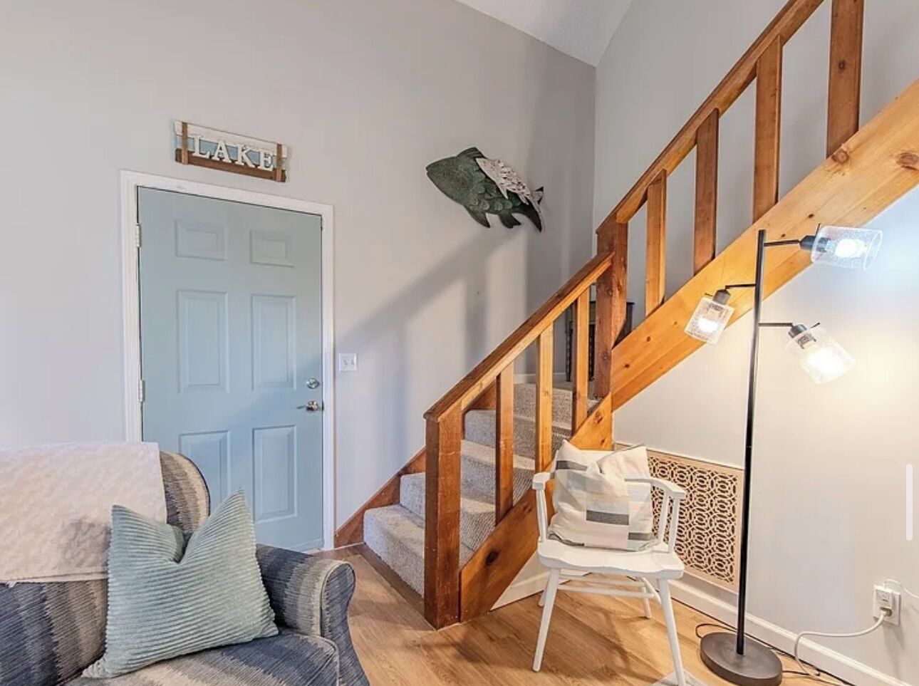 Un escalier avec des rampes en bois et un luminaire placé au-dessus.