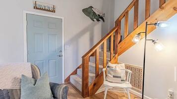 Un escalier avec des rampes en bois et un luminaire placé au-dessus.