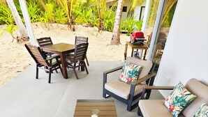 Une terrasse extérieure avec une table en bois, deux canapés et des chaises.