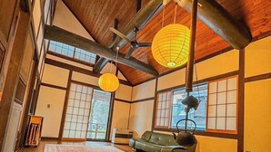 Un interior japonés tradicional con suelo de tatami, una mesa de madera baja y puertas correderas.