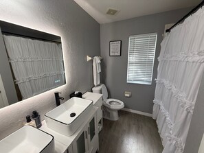 Ein Badezimmer mit Waschbecken, Toilette und Duschvorhang.