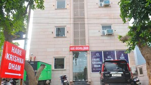 A building with a sign reading "Hare Krishna Dharma" and a parked black SUV. - Hotel Hare Krishna Dham (Mathura)