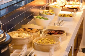 A buffet with various dishes in wooden and white bowls, including salads, meats, and desserts. - XANA Deluxe International Hotel Dongshankou Metro Station Branch (Guangzhou)