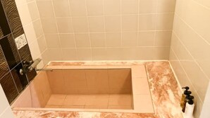 A bathtub with a marble countertop and a shower area. - HOTEL LiVEMAX Naha Naminoue I (Naha)