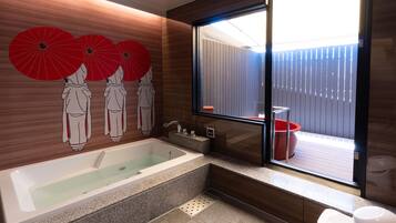 A modern bathroom with a bathtub, a window with a view of a wooden deck, and decorative red umbrellas on the wall.