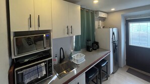 A compact kitchen with a microwave, toaster, sink, and a refrigerator. - Casita Heliconia- Jr. Suite#3 (Roseau)