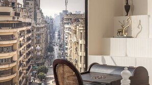 Une chambre avec vue sur une rue de la ville, un bureau, une chaise et un lit.