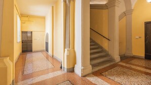 A hallway with a staircase, columns, and a door. - Ciao Bologna Collection - San Martino (Bologna)