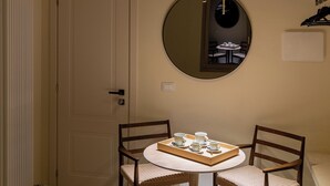 A room with a round table, two chairs, a hanging light fixture, a mirror, and a door. - Ciao Bologna Collection - San Martino (Bologna)