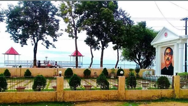 A fenced park area with a gazebo, a statue, and a building with a mural. - Haor Bilash Guest House (Sunamganj)