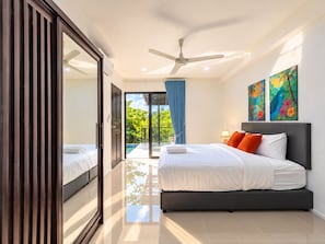 Ein modernes Schlafzimmer mit Bett, Deckenventilator und Blick auf einen Swimmingpool.