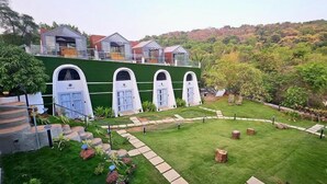 A modern building with multiple arched windows and a green exterior. - Nyast Valley Resort (Arpora)