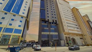 A hotel with a modern facade, multiple floors, and a prominent entrance.