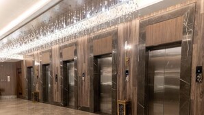 Et moderne elevatormiljø med marmorgulv og træpaneler.