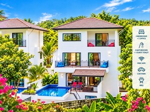 A two-story hotel with a swimming pool, balconies, and a sign listing amenities like bedrooms, office, bathrooms, guest toilet, free WiFi, car park, and BBQ. - Tropical Private Pool Villa Phuket (ตำบล ฉลอง)